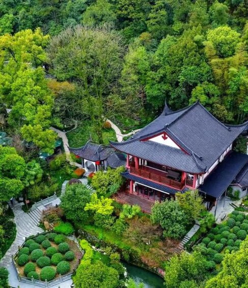 A traditional Chinese building with a curved roof, surrounded by lush greenery and a winding pathway. 1