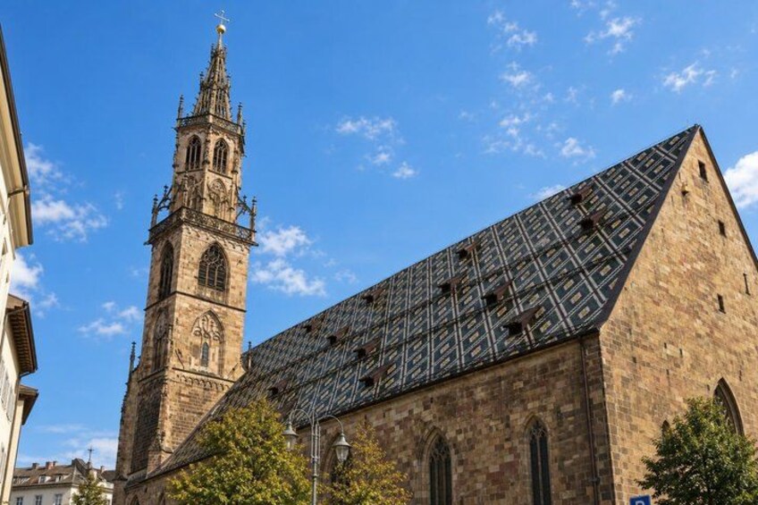 A historic church with a tall tower and a modern metal roof. 3