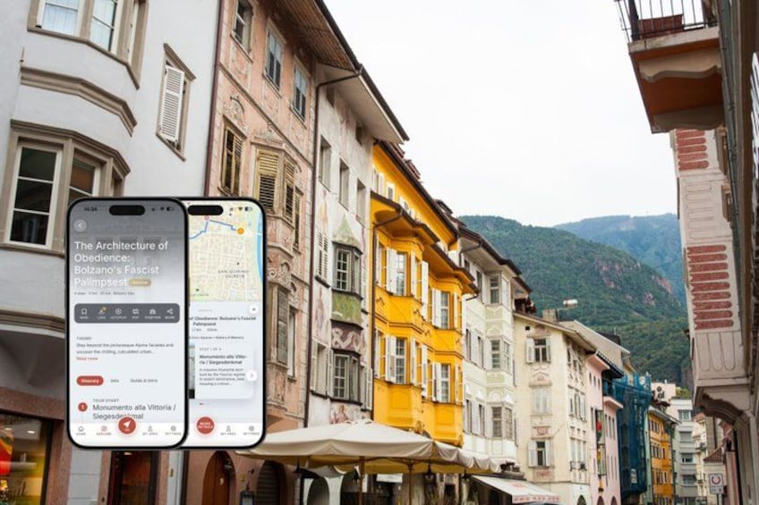 A street with colorful buildings, a smartphone displaying a map, and a sign with text. 1