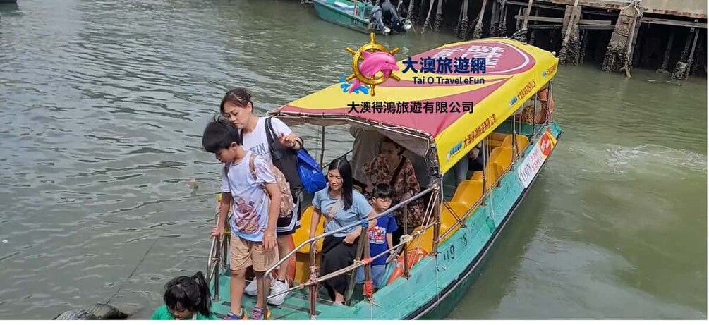 Un bateau transportant des passagers, un auvent aux couleurs vives et un logo. 1