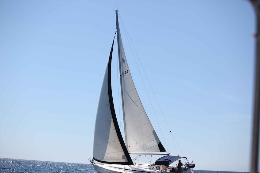 Ein Segelboot mit großem Segel an einem sonnigen Tag. 4