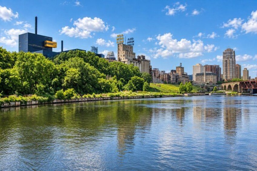 A river with a city skyline in the background, including a bridge and various buildings. 4