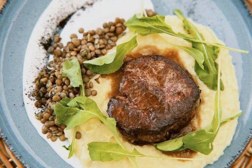 A plate with a steak, lentils, and greens. 3