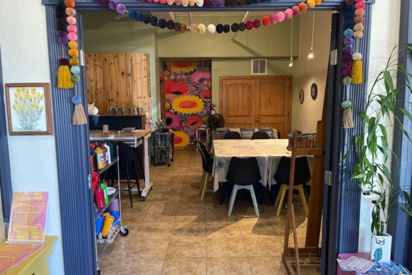 A dining area with a table, chairs, a wooden cabinet, and a colorful wall mural. 2