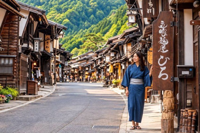 A traditional Japanese street with wooden buildings, a person in a blue kimono, and a sign with Japanese characters. 4