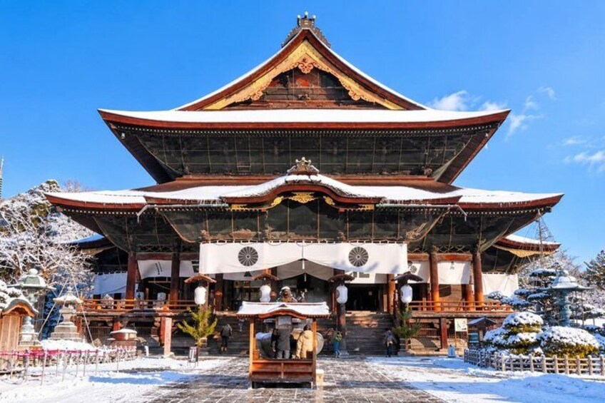 A traditional Japanese building with a snow-covered roof and a large central entrance. 3
