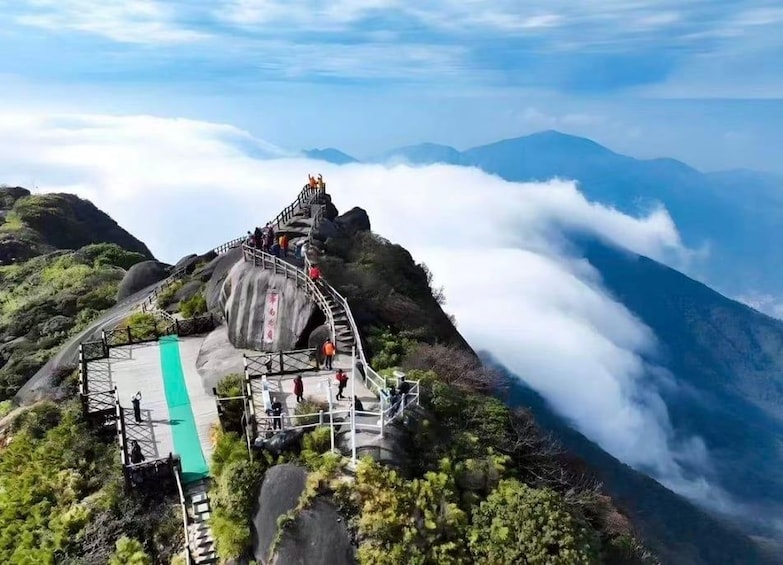 A mountain trail with a staircase leading to a viewing platform. 1