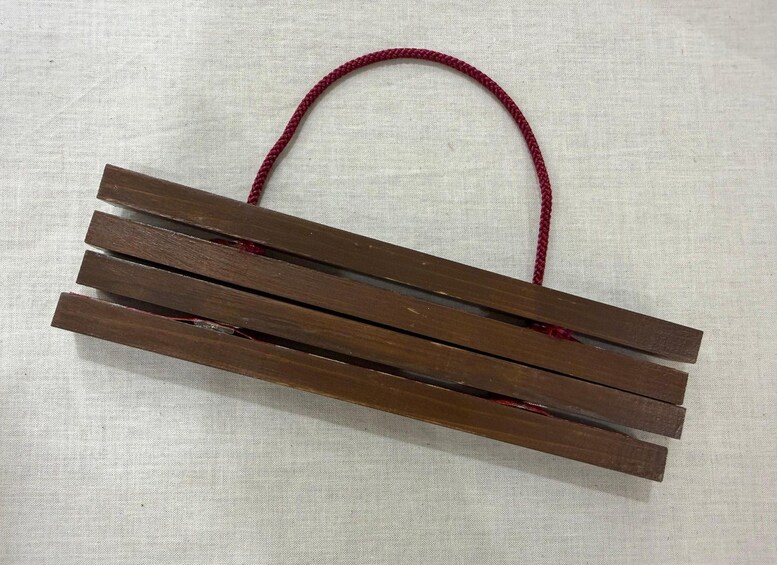 Un objet en bois doté d’un manche rouge. 5