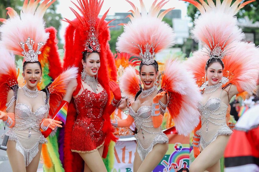 Un groupe d’artistes vêtus de costumes élaborés, ornés de coiffes à plumes et d’accessoires étincelants. 2