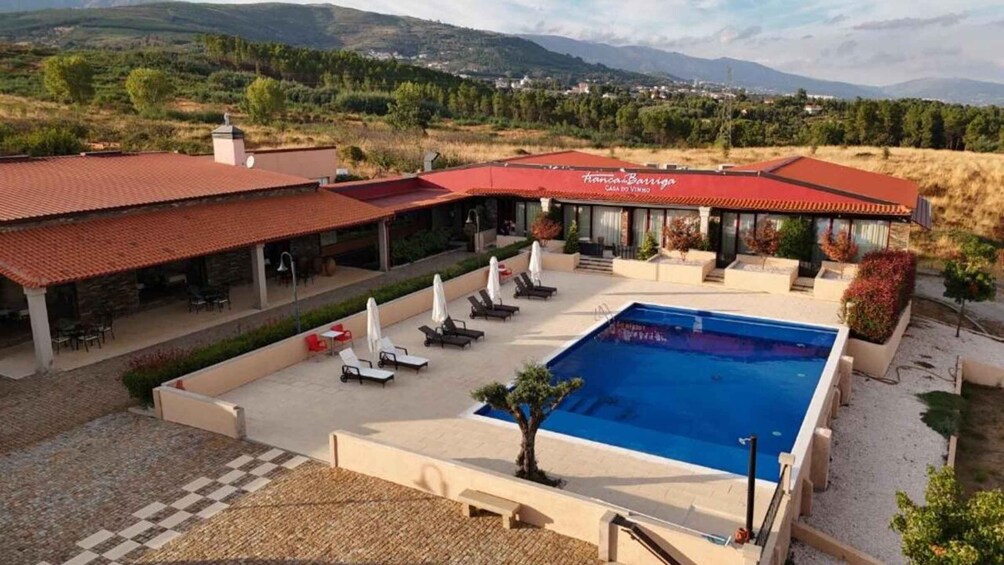 A villa with a swimming pool, outdoor seating, and a view of the surrounding landscape. 2