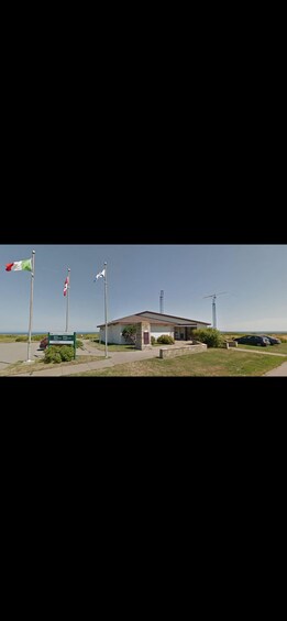 Un bâtiment avec un mât sur lequel flotte un drapeau, une enseigne et un ciel dégagé. 2