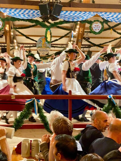Un grupo de personas bailando con trajes bávaros tradicionales. 4
