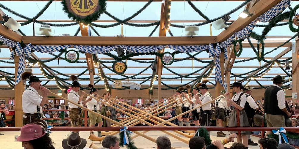 Un festival tradicional de cerveza bávaro con estructuras de madera, decoraciones festivas y asistentes con trajes típicos. 5