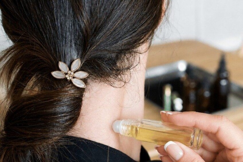 A person with a flower hair accessory and holding a bottle. 5
