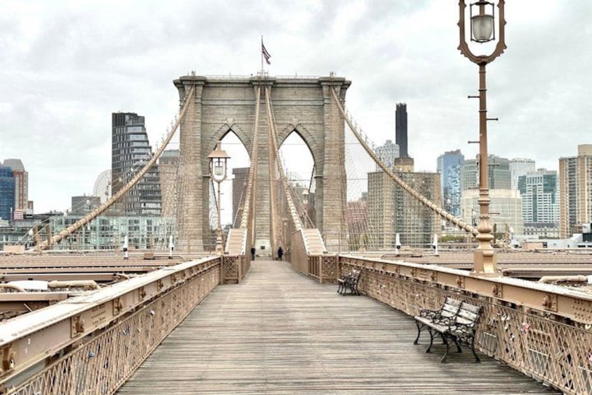 A bridge with a wooden walkway, metal railings, and a city skyline in the background. 4