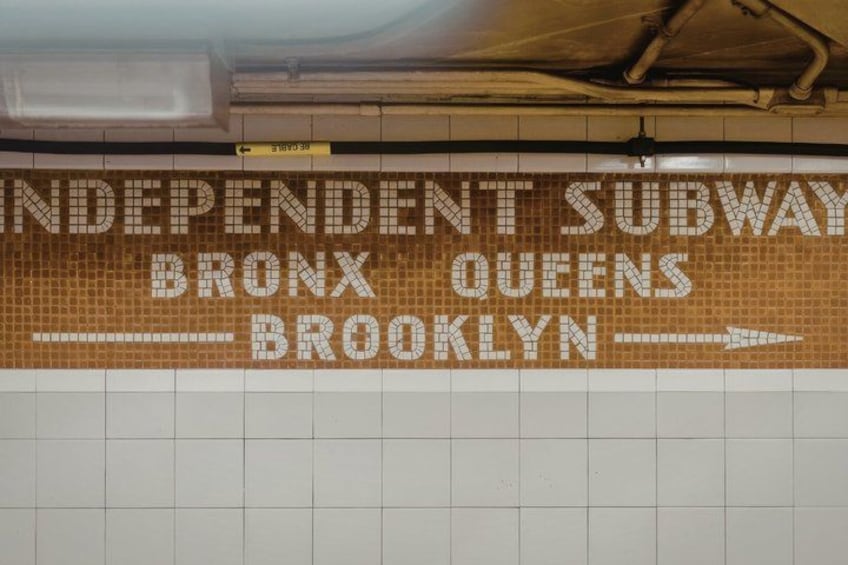 A subway station sign with 'INDEPENDENT SUBWAY BRONX QUEENS BROOKLYN' and an arrow pointing right. 5