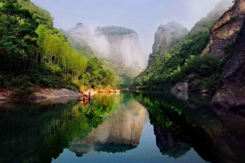 A calm river surrounded by lush greenery and rocky cliffs. 2