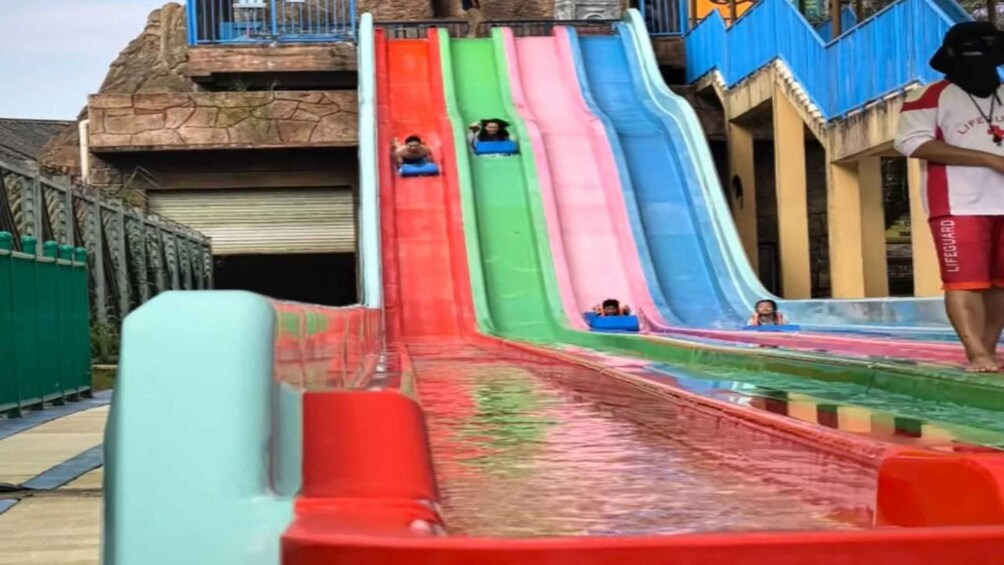 A water park with multiple slides in red, green, blue, and pink. 3