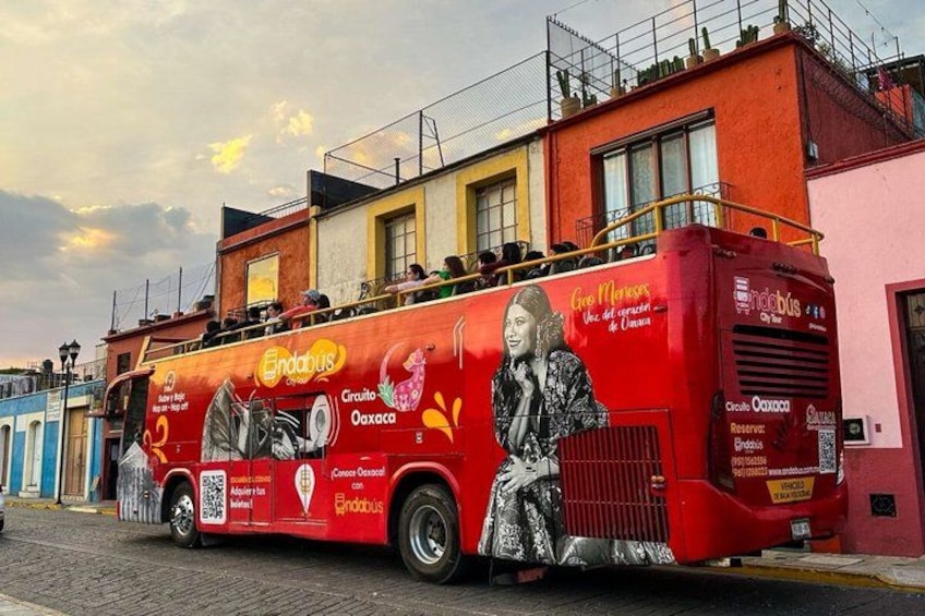 A red double-decker bus with advertisements for Endibus and Oaxaca. 1