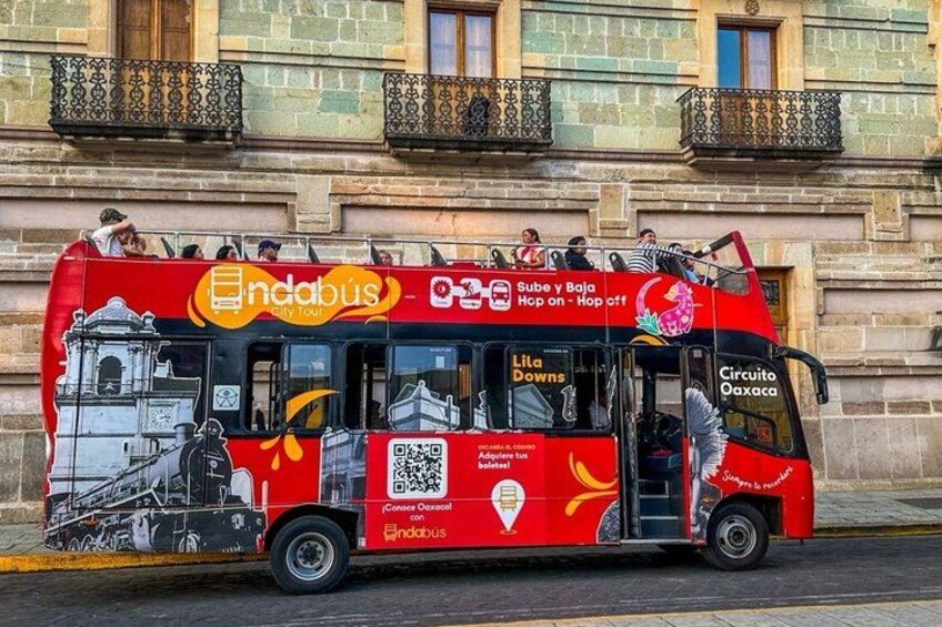 A red tour bus with 'ndabus' branding and 'Circuito Oaxaca' text. 3