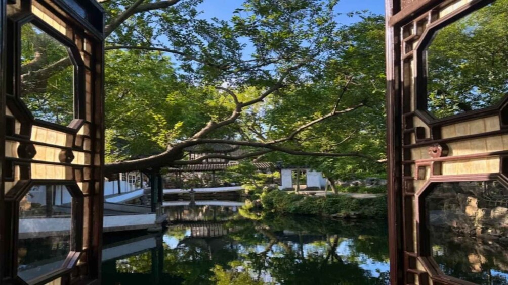 A tranquil garden with a reflective pond, wooden bridges, and lush greenery. 1