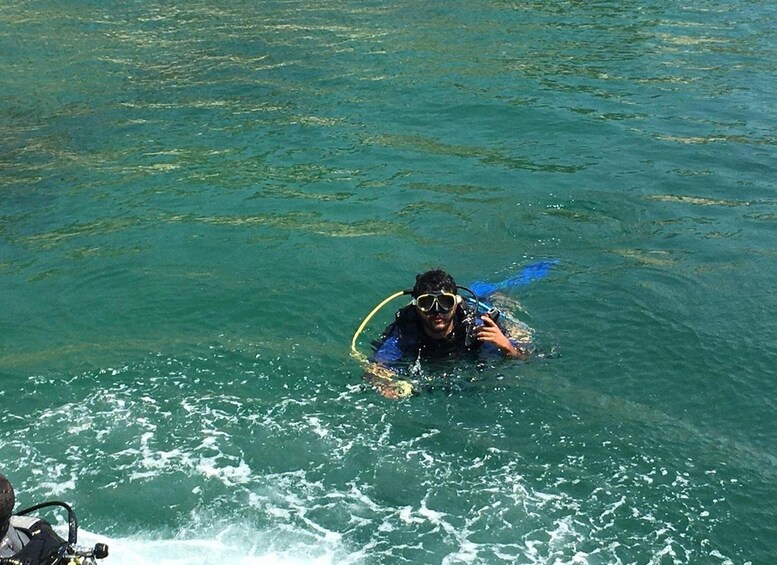 Eine Person taucht in klarem, blauem Wasser. 5