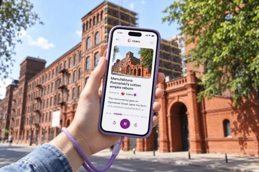 A hand holding a smartphone displaying a webpage about Poznań's cotton empire. 1
