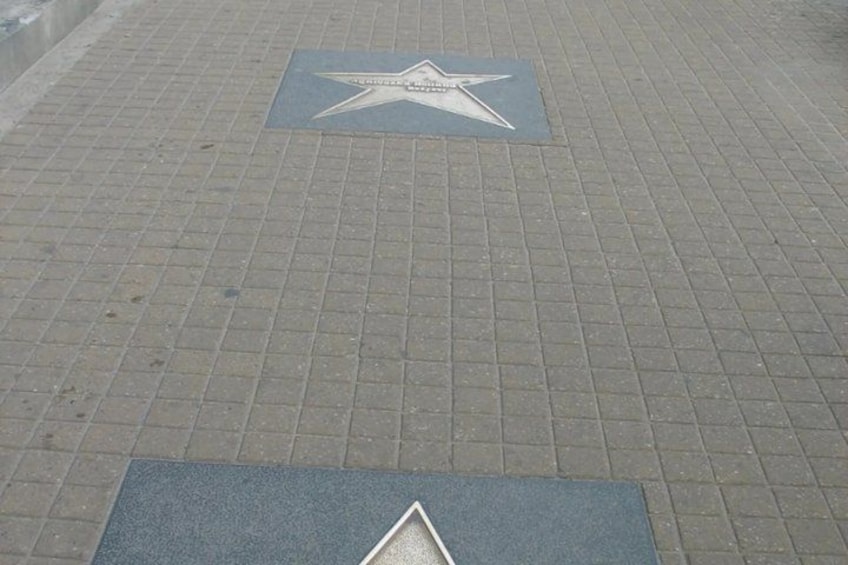 A star-shaped pavement marking on a brick sidewalk. 4