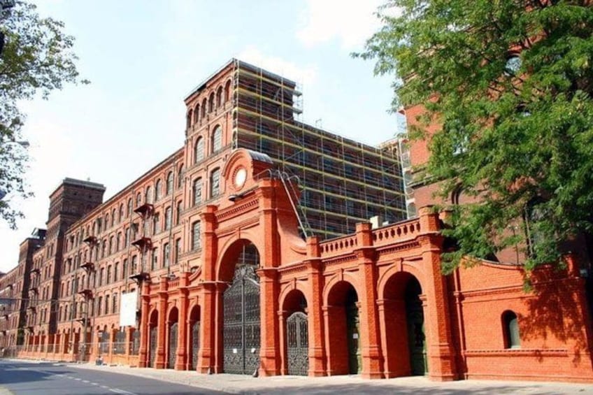 A historic red brick building with arched windows and a large central archway. 3