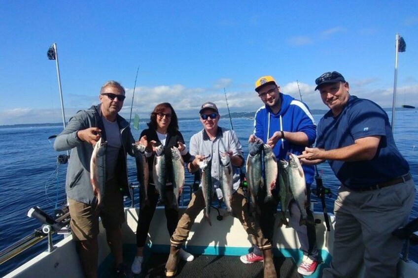 A group of people on a boat holding fish. 5