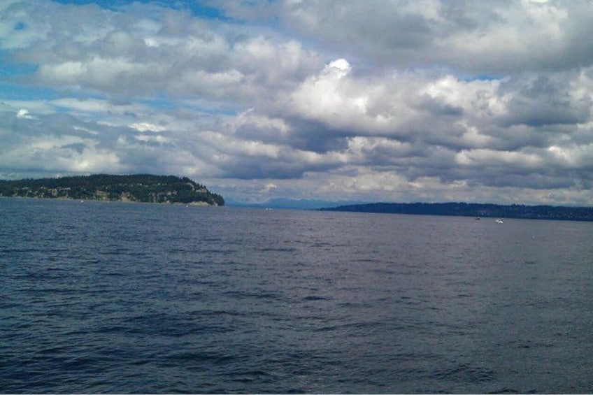 A body of water with a distant landmass and a cloudy sky. 2