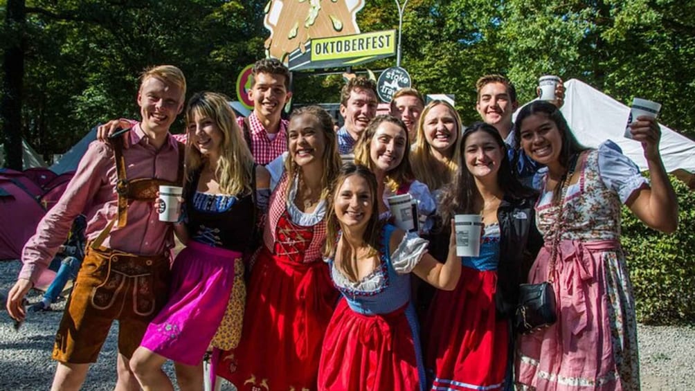 A group of people in traditional Bavarian attire posing for a photo at Oktoberfest. 1
