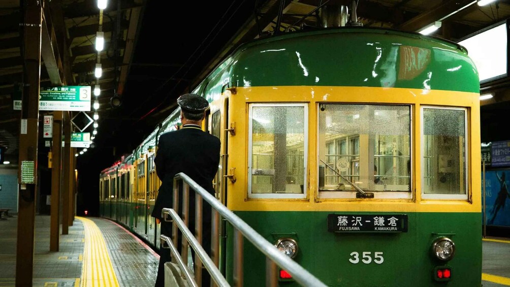 Un tren verde y amarillo con el número 355 en el andén de una estación. 5
