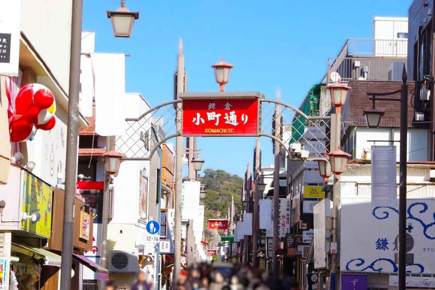 Una calle concurrida con un letrero rojo que indica 'KOMACHI ST'. 2