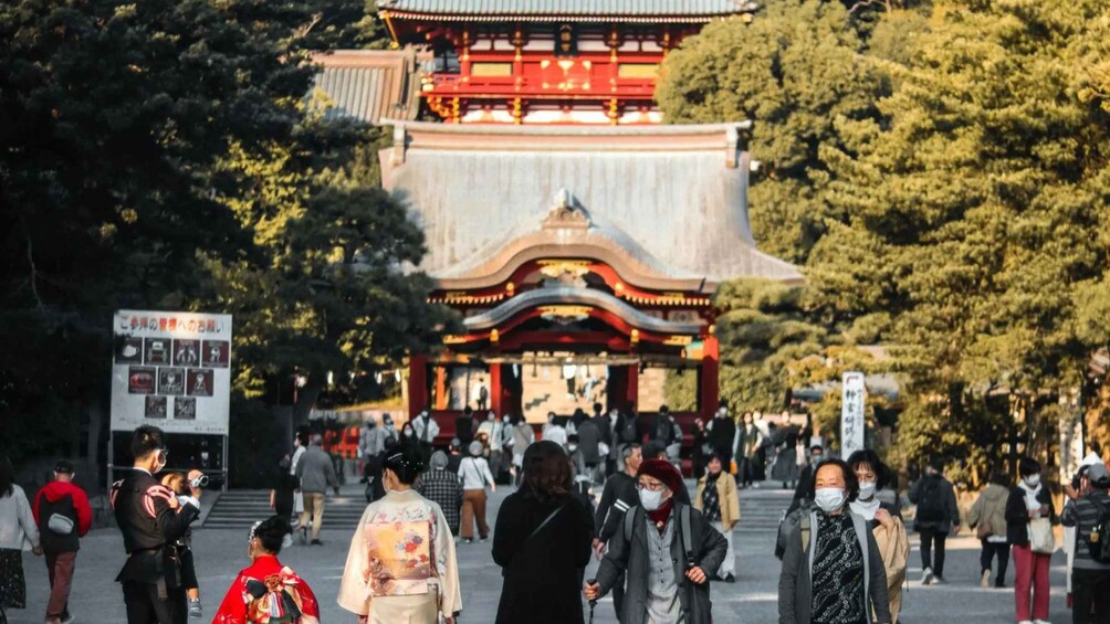 Un torii tradicional japonés con gente caminando a su alrededor. 3