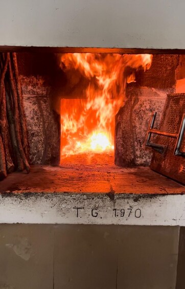 Ein Holzofen mit Flammen und einer Metallleiter. 4