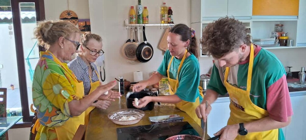 Un groupe de personnes se trouve dans une cuisine et prépare des aliments. 4