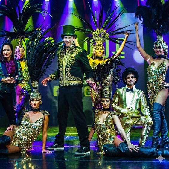 Un grupo de personas con trajes elaborados en un escenario con un fondo de hojas de palma y el logotipo de 'YouTube'. 4