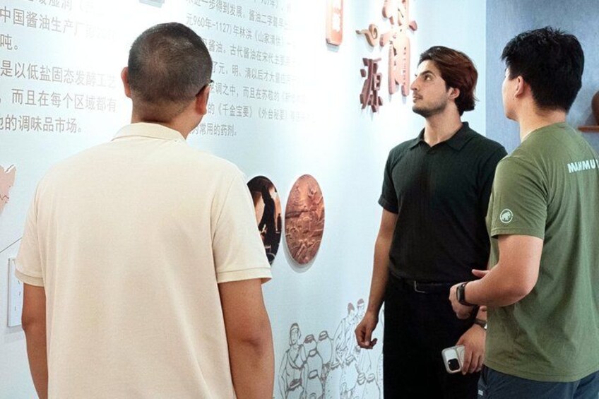 Un grupo de personas observando una pared con texto e imágenes. 5