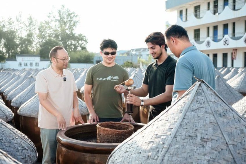 Un grupo de personas observando grandes macetas de cerámica al aire libre. 3