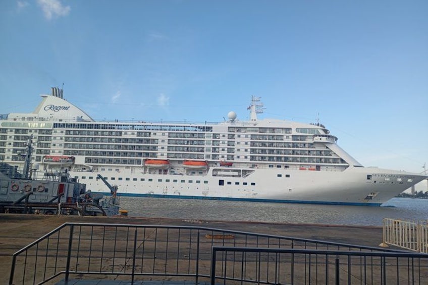 A large cruise ship docked at a port with a clear sky. 1