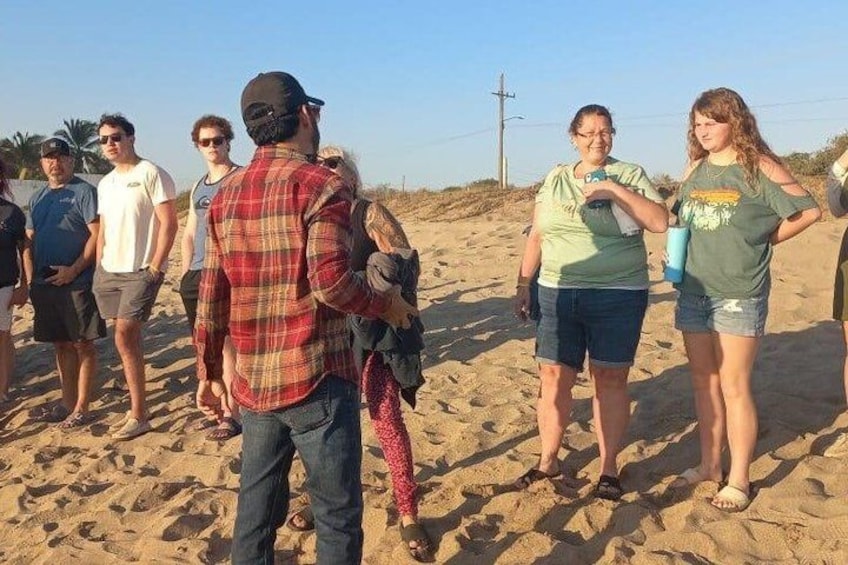 A group of people on a sandy beach with a clear sky. 3