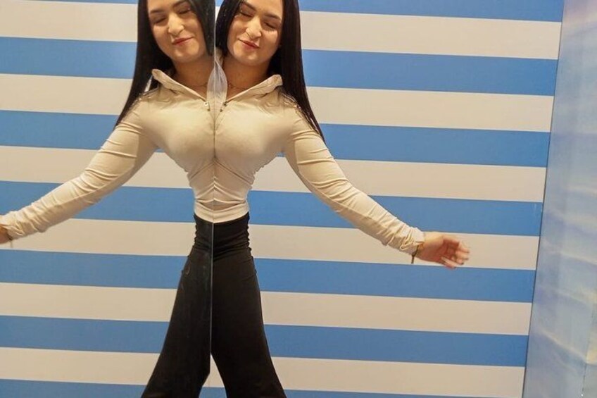 A person standing with arms outstretched in front of a striped wall. 3