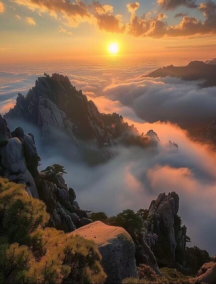 A sunrise over a mountainous landscape with rocky formations and a sea of clouds below. 2