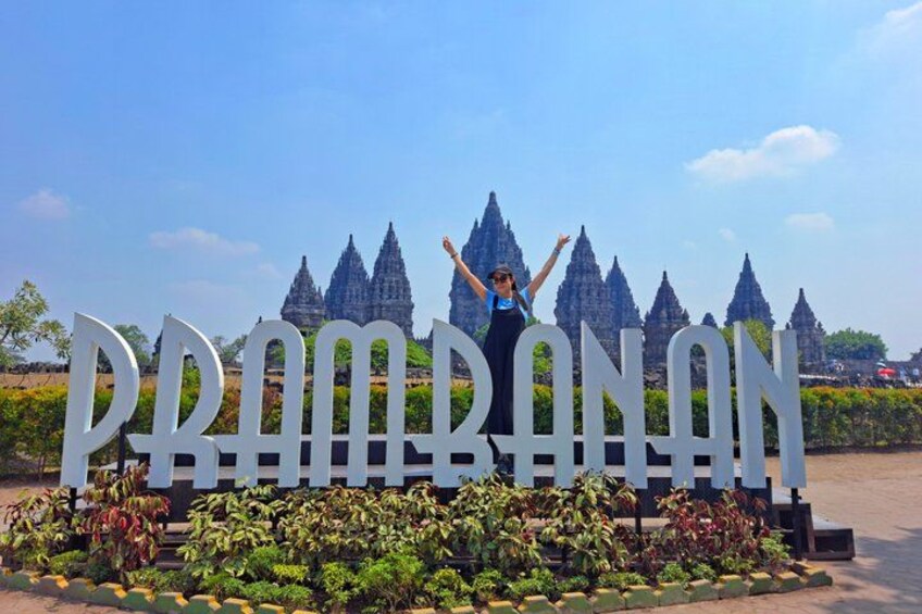 A person standing in front of a large sign with the text 'PRABANAN' and a temple in the background. 1