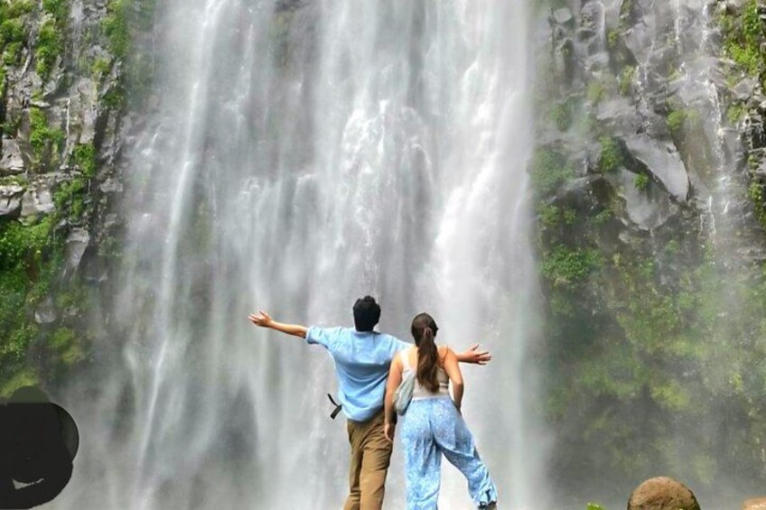 A waterfall with a person standing in front of it. 4
