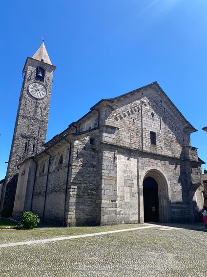 Una iglesia de piedra histórica con un campanario y un reloj. 1