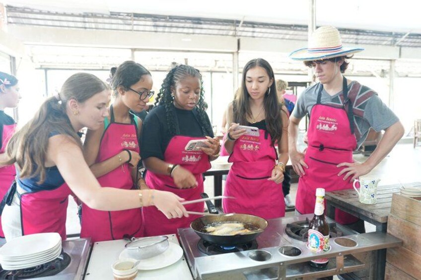 People cooking in an outdoor kitchen. 5