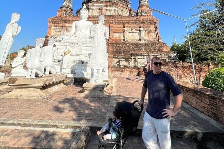 Una persona de pie frente a un templo con grandes estatuas de Buda y una estupa. 4