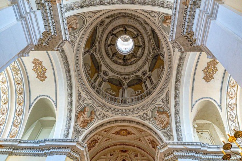 A grand architectural ceiling with intricate carvings and a central circular design. 4